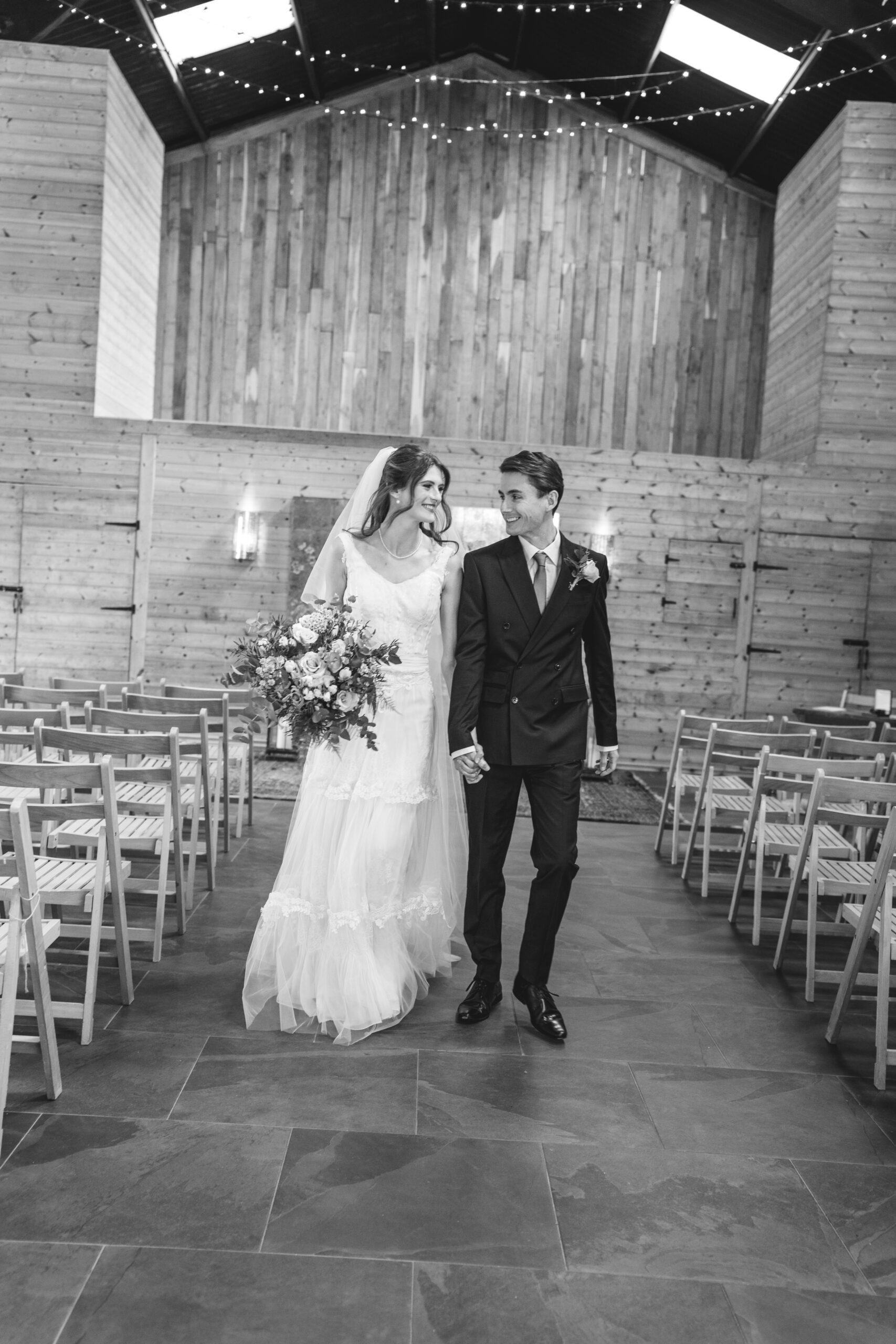 Bride and Groom walking down the barn 