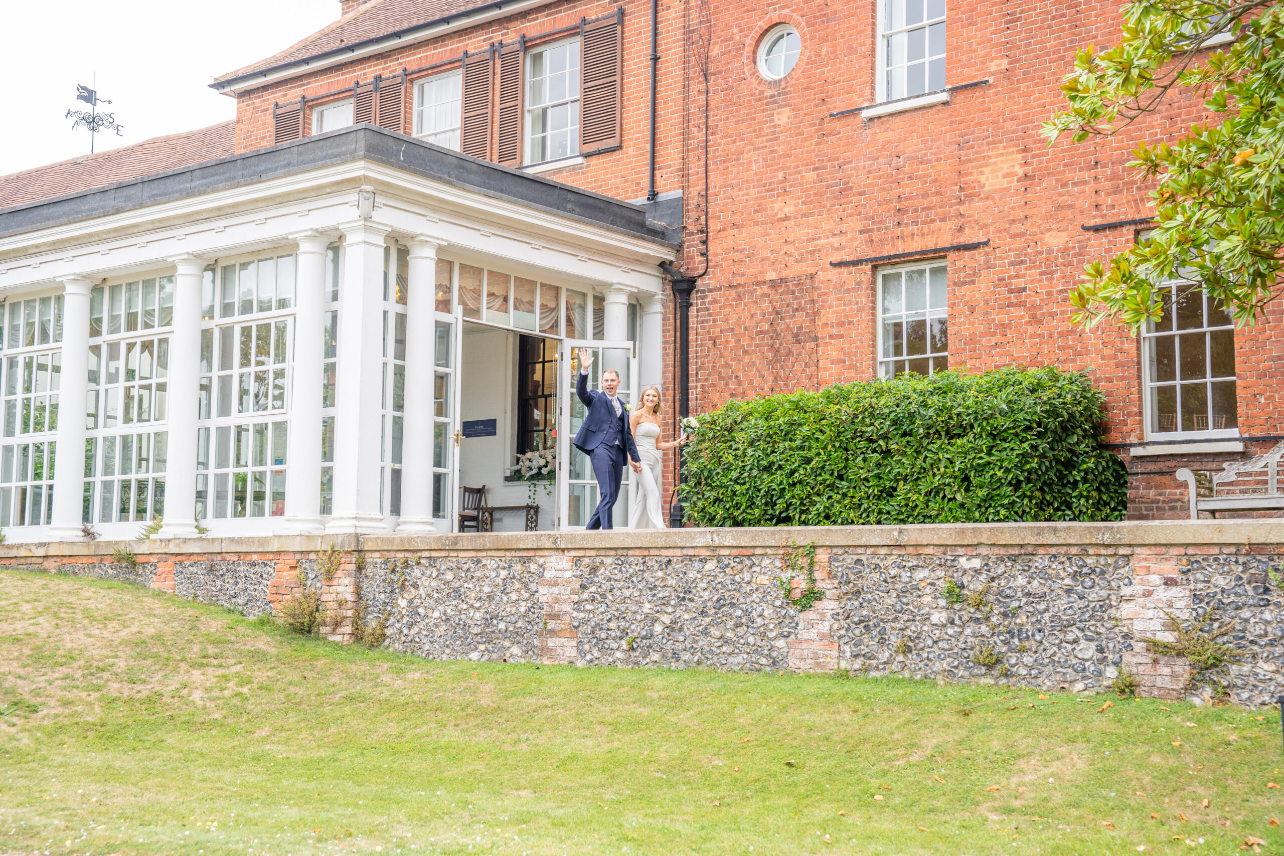 couple walking out of Leatherhead registry office towards guests