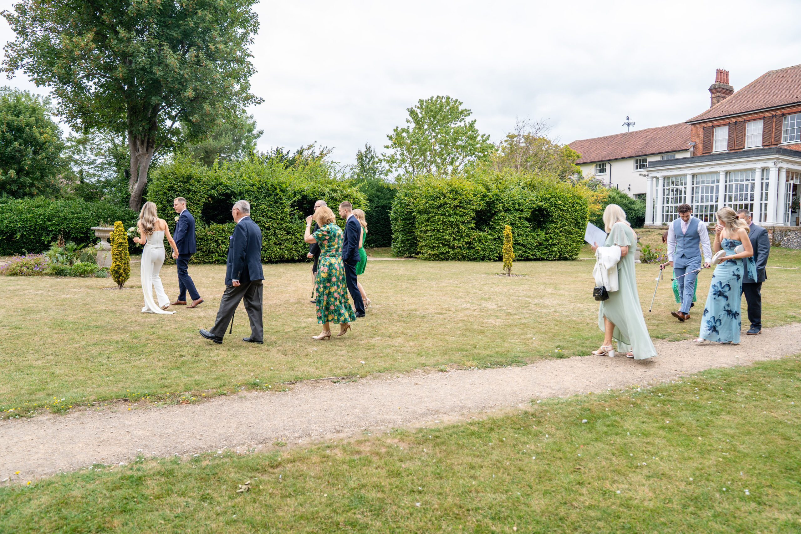 Guests mingling in the garden after ceremony.