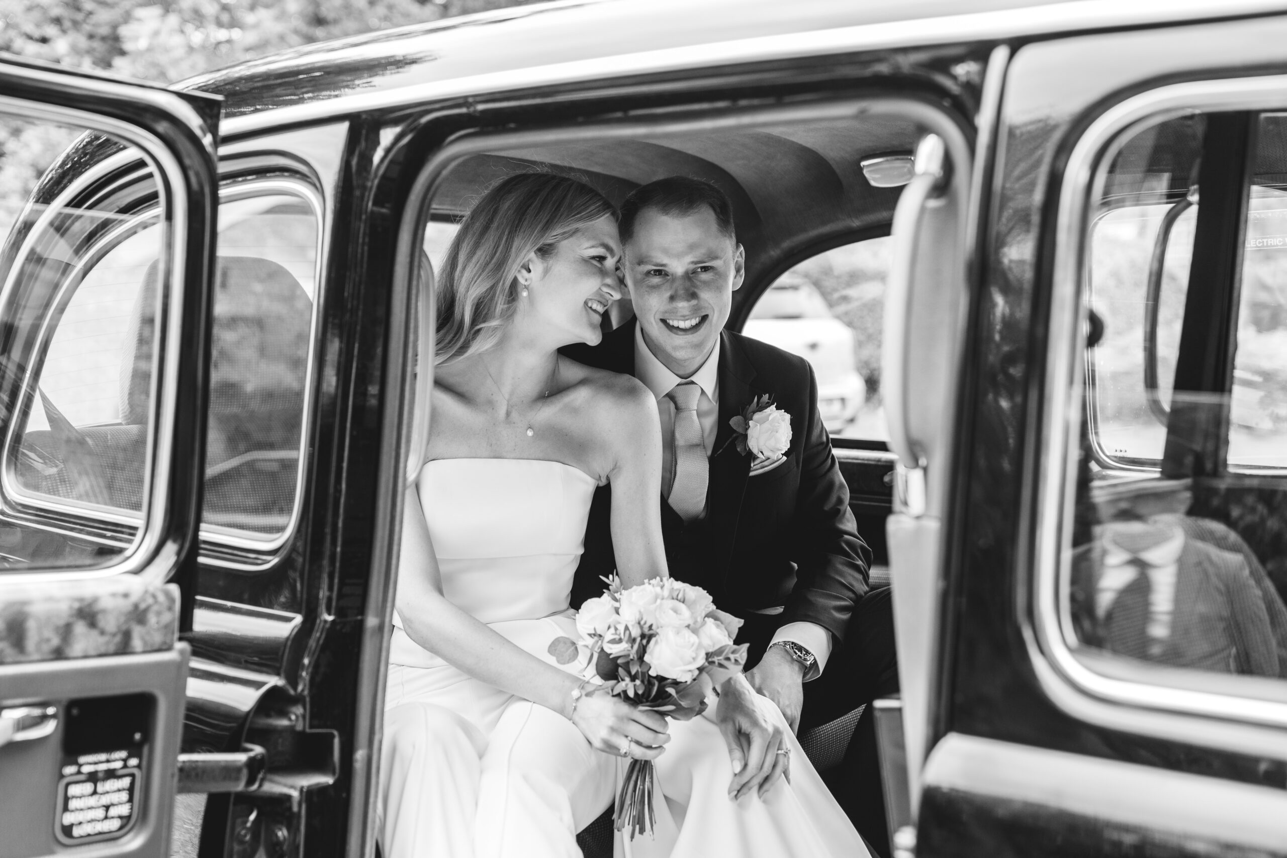 Relaxed portraits leaving in a taxi for the reception photographed by Surrey wedding photographer