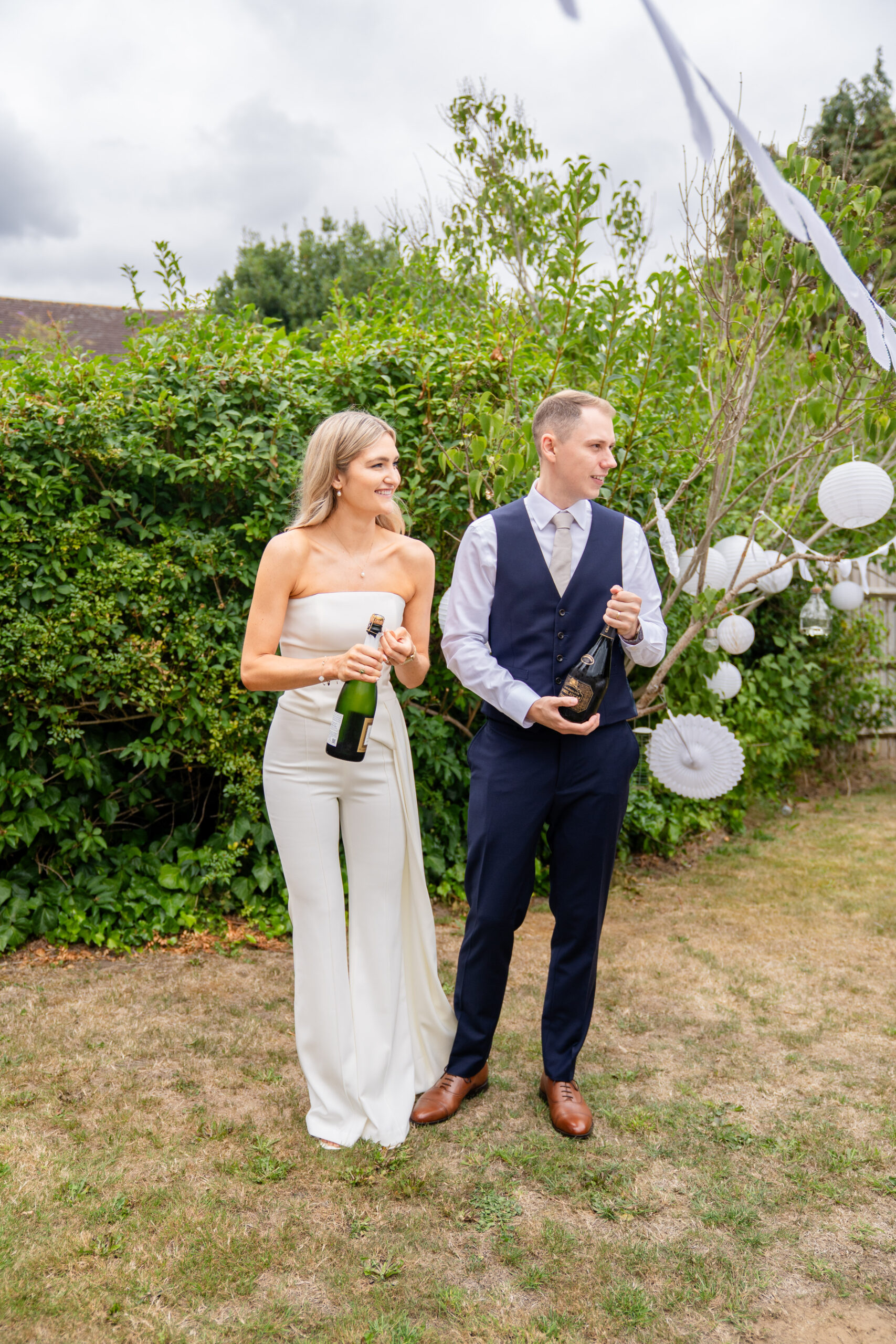 Champagne pop in the garden in photographed by Surrey wedding photographer