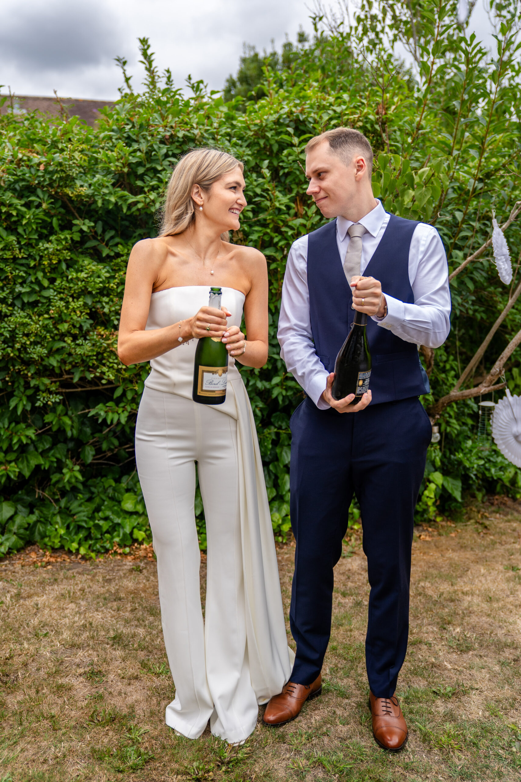 Champagne pop in the garden in photographed by Surrey wedding photographer