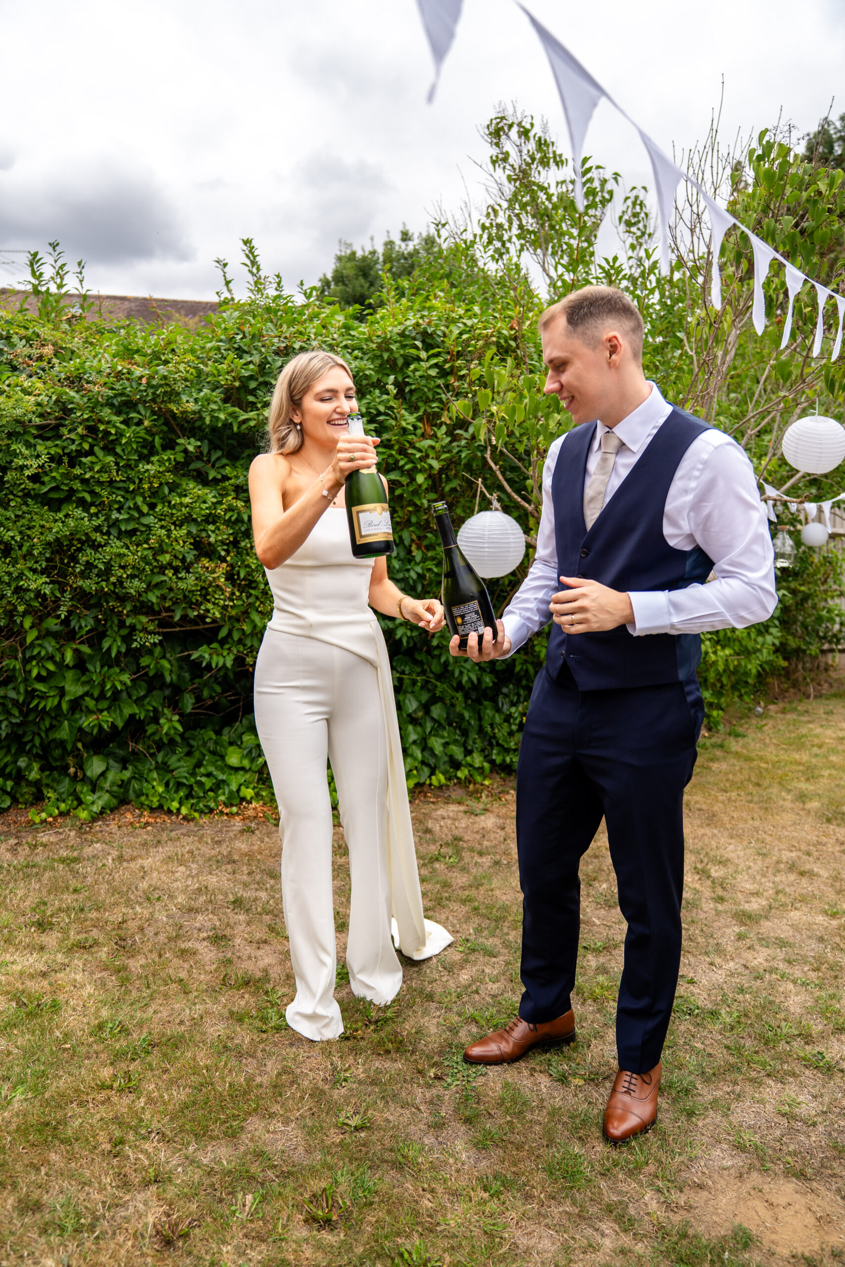 Champagne pop in the garden in photographed by Surrey wedding photographer