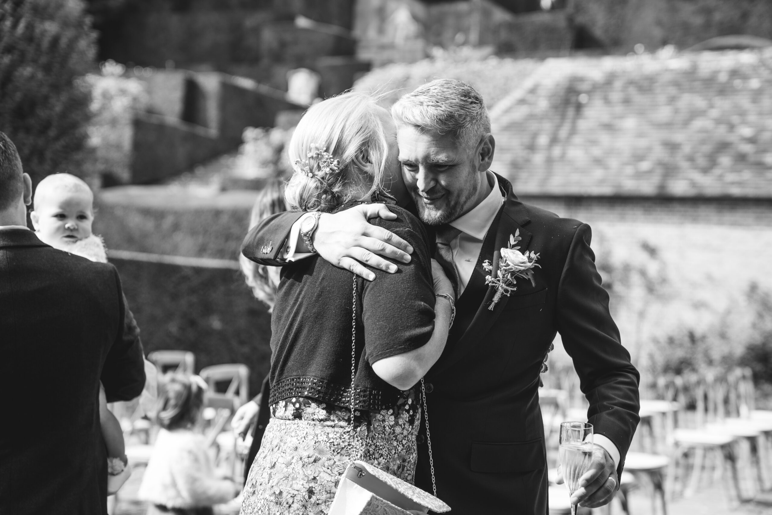 Candid moment of groom and guest hugging after ceremony in Kent  at Port Lympne. One of my favourite wedding venue in kent.