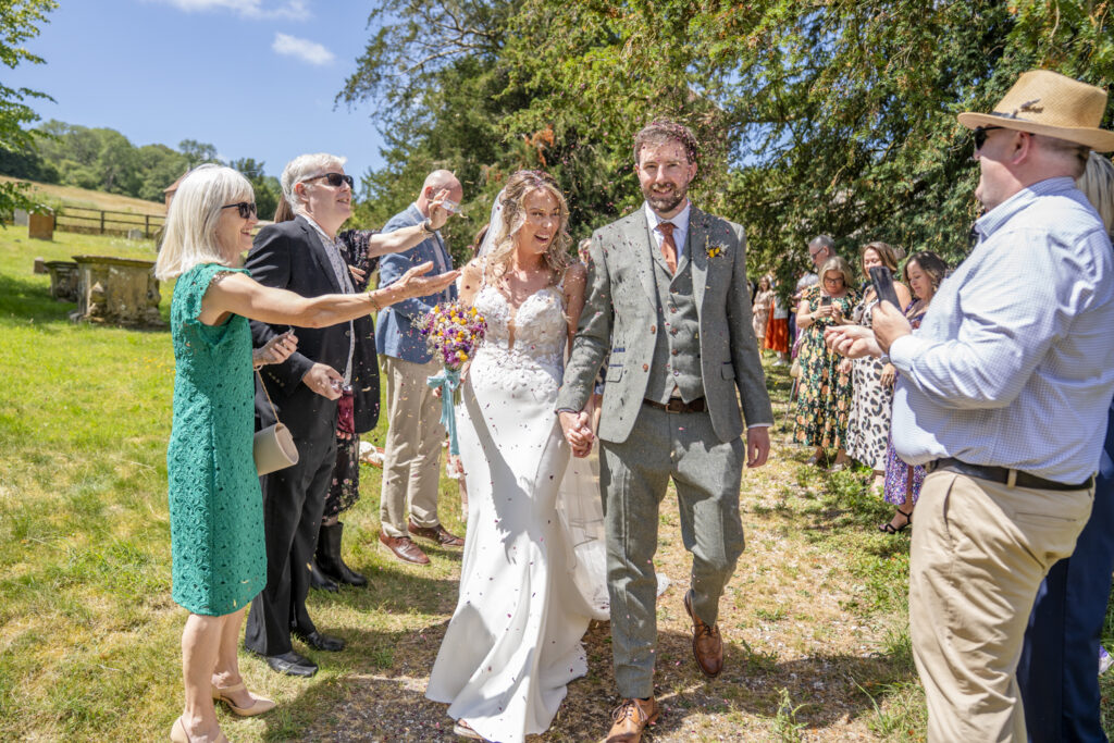 Confetti moment between bride and groom and guests outside the church